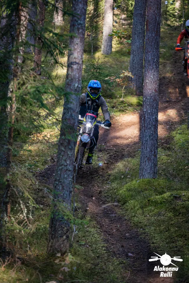 Alakonnu Ralli 2026: mootorrattur läheneb mööda kitsast rada samblases männimetsas.