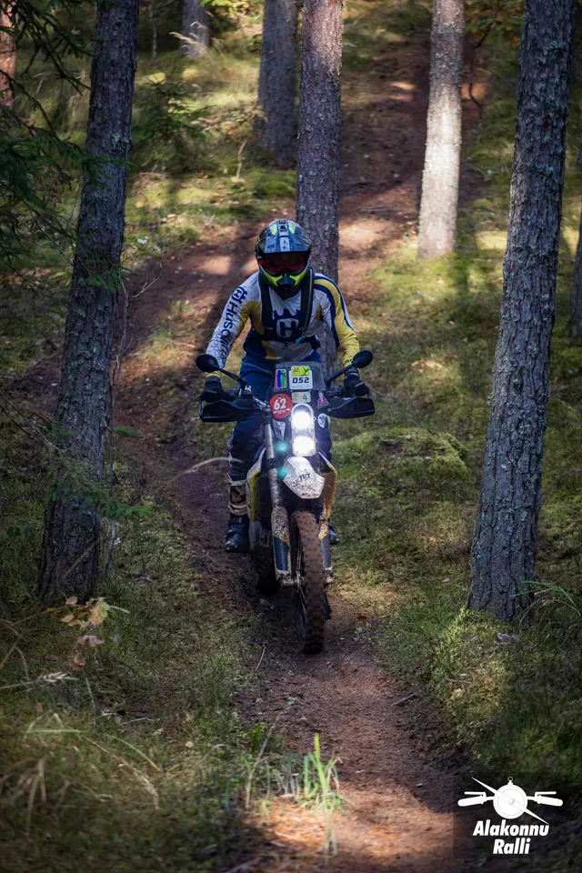 Alakonnu Ralli 2026: mootorrattur läheneb mööda looklevat rada männipuude vahel.
