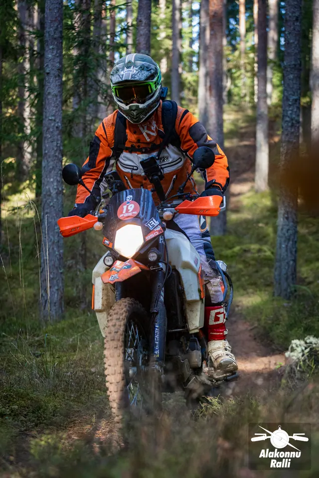 Alakonnu Ralli 2026: oranžis sõiduvarustuses mootorrattur sõidab mööda samblast metsarada.