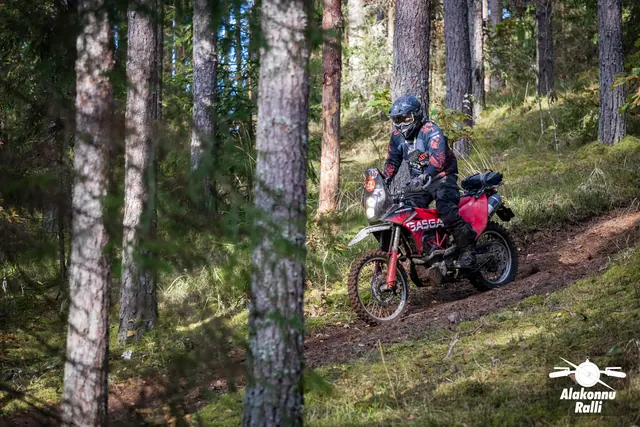 Alakonnu Ralli 2026: sõitja punaste külgpaneelidega mootorrattal läbib metsarada.