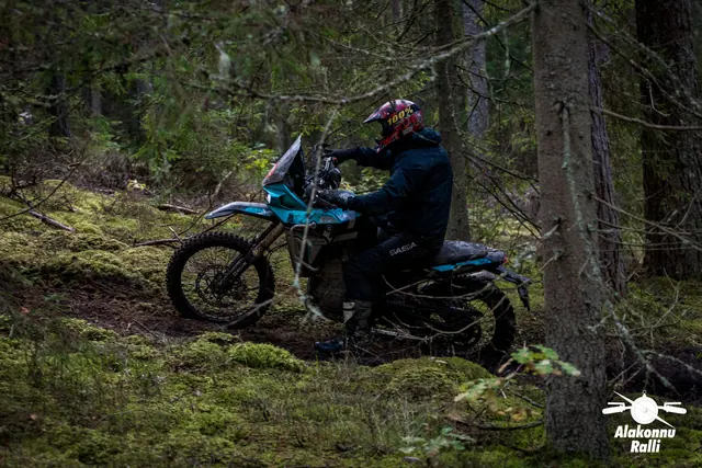 Alakonnu Ralli 2026: sõitja heledal matkaenduromootorrattal samblases metsas külgvaates.