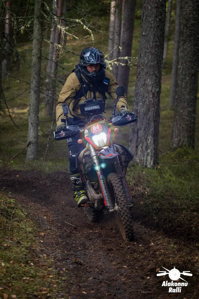 Alakonnu Ralli 2026: pruuni ja musta varustusega sõitja läheneb mööda metsarada.