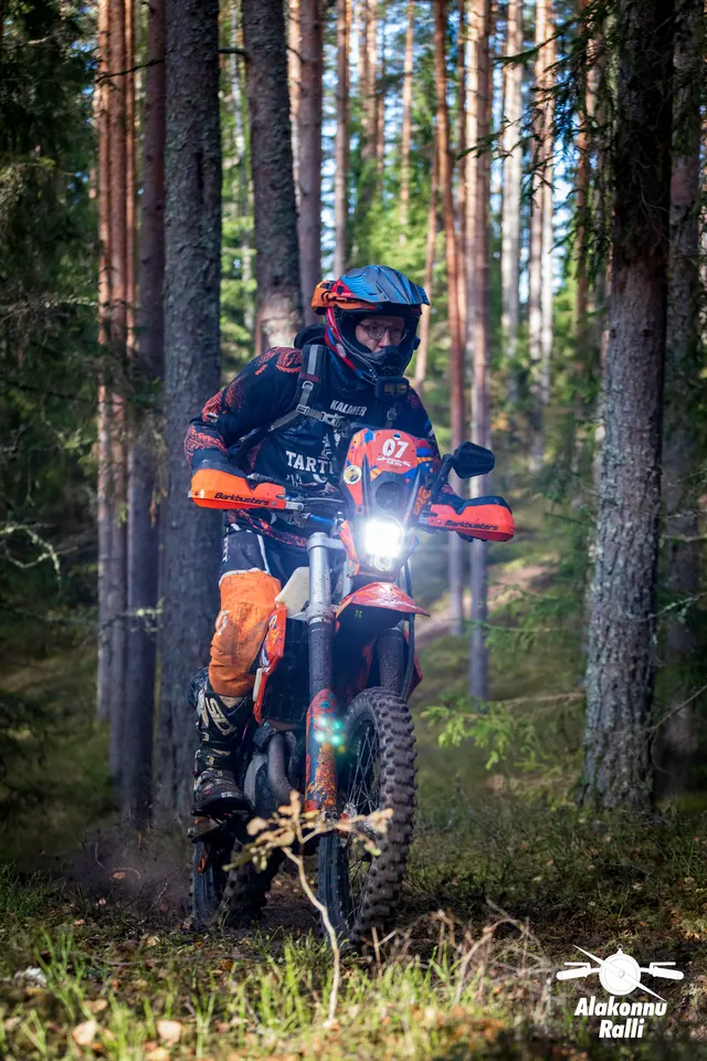 Alakonnu Ralli 2026: oranži ja musta varustusega sõitja oranžil rattal metsarajal.