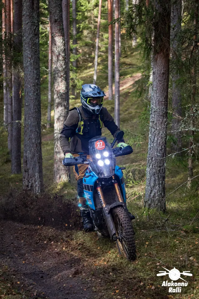 Alakonnu Ralli 2026: mootorrattur sinisel rattal kallutab kurvis männimetsa rajal.