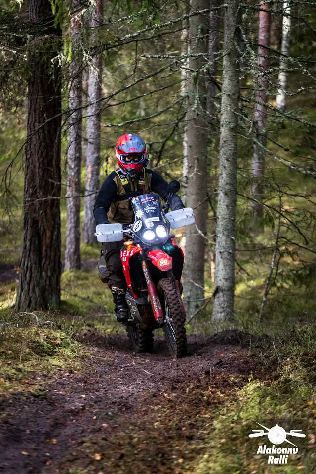 Alakonnu Ralli 2026: punase kiivriga sõitja punasel mootorrattal metsakurvis.