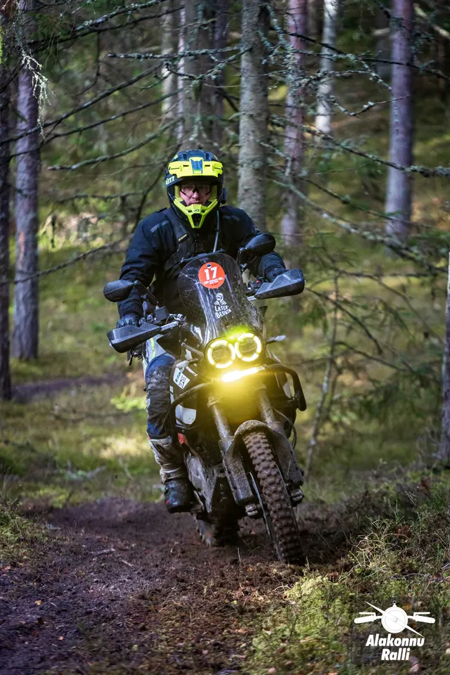 Alakonnu Ralli 2026: kollaste ümarate esituledega mootorratas metsaraja kurvis.