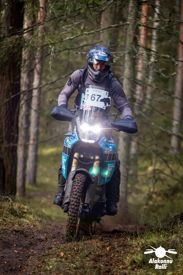 Alakonnu Ralli 2026: halli jakiga sõitja sinisel matkaenduromootorrattal männimetsas.