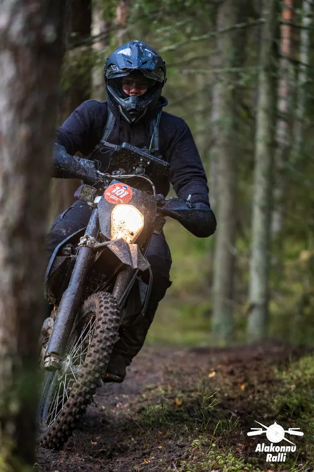Alakonnu Ralli 2026: mustas varustuses mootorrattur kallutab ratast metsaraja kurvis.