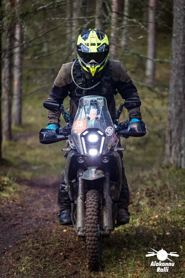 Alakonnu Ralli 2026: kollase kiivriga sõitja tumedal matkaenduromootorrattal läheneb metsas.