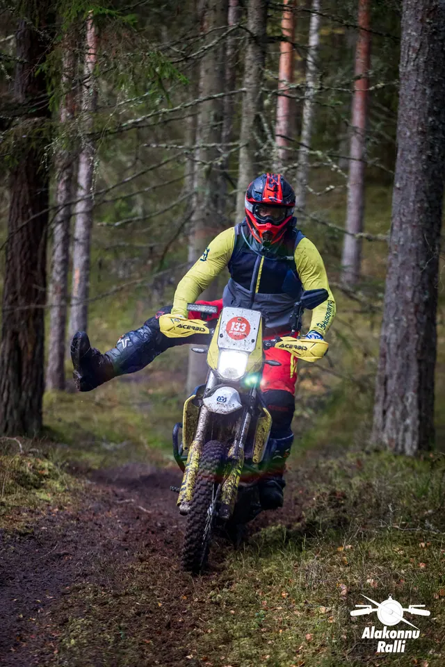 Alakonnu Ralli 2026: kollase jakiga sõitja sirutab jala küljele metsarajal.