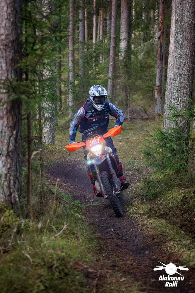 Alakonnu Ralli 2026: mootorrattur oranžil rattal kallutab kitsal metsarajal.