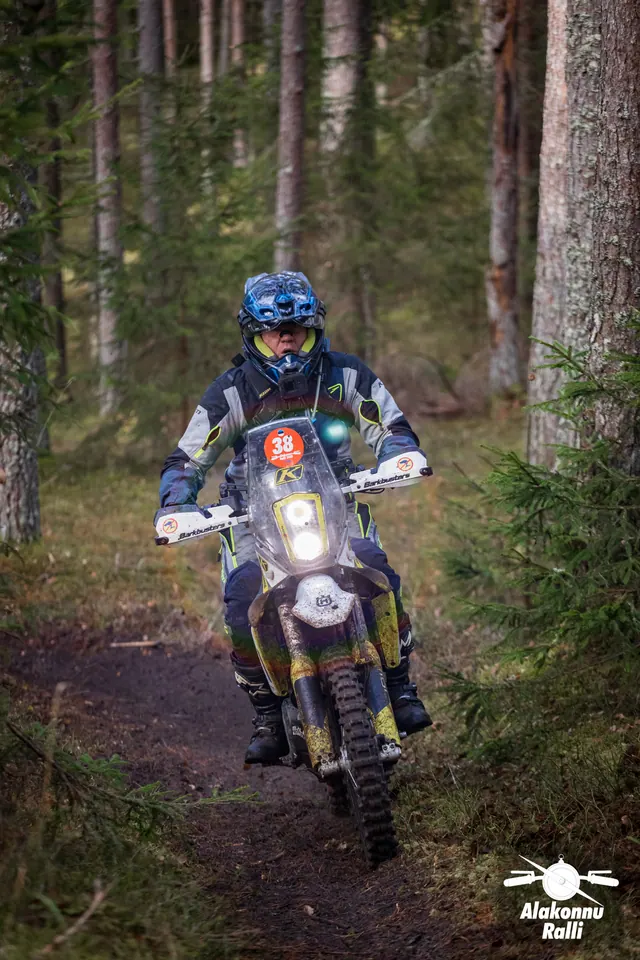 Alakonnu Ralli 2026: sinise kiivriga sõitja kollase ja sinise mootorrattaga läheneb metsas.