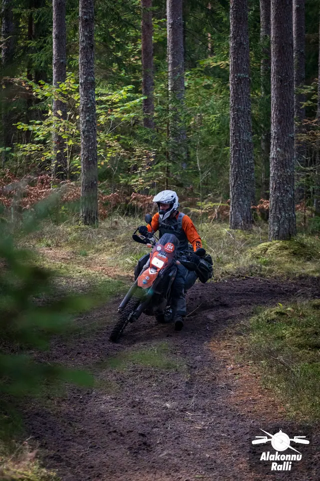 Alakonnu Ralli 2026: oranžis varustuses sõitja kallutab ratast laiemas metsakurvis.
