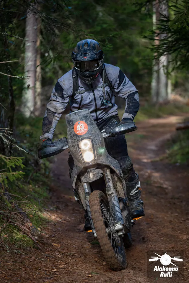 Alakonnu Ralli 2026: halli varustusega sõitja porisel kõrge tuuleklaasiga mootorrattal.