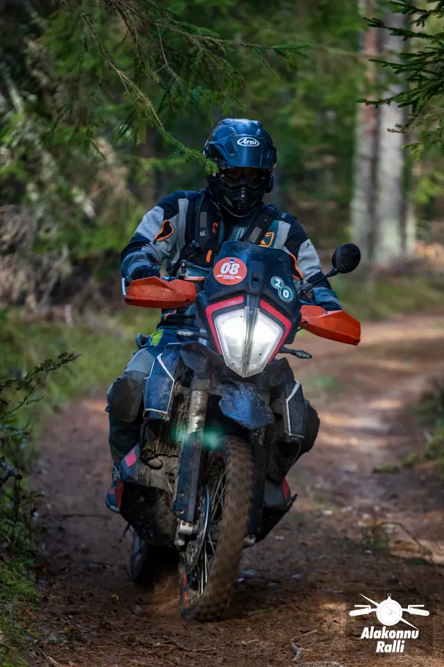 Alakonnu Ralli 2026: sinise kiivriga sõitja tumedal oranžide käekaitsmetega mootorrattal.