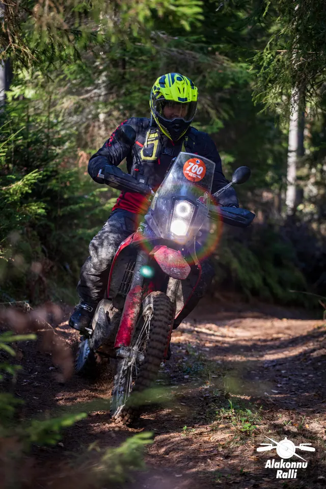 Alakonnu Ralli 2026: kollase kiivriga sõitja punase esiporilauaga rattal metsakurvis.