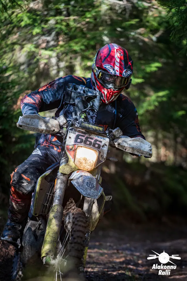 Alakonnu Ralli 2026: punase kiivriga sõitja heledal enduromootorrattal metsakurvis.