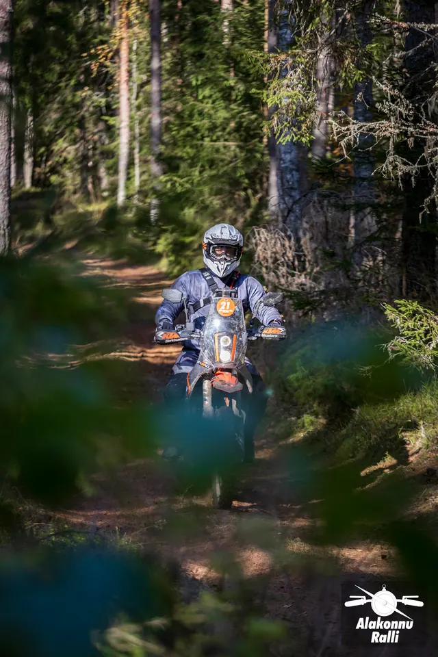 Alakonnu Ralli 2026: mootorrattur läheneb metsarajal esiplaanil olevate okste tagant.