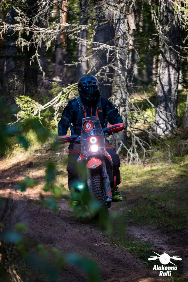 Alakonnu Ralli 2026: mootorrattur punase esiporilauaga rattal kitsal metsarajal.