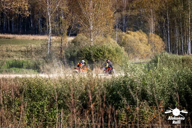 Alakonnu Ralli 2026: kaks mootorratturit sõidavad eemal mööda teed sügisese võsa taga.