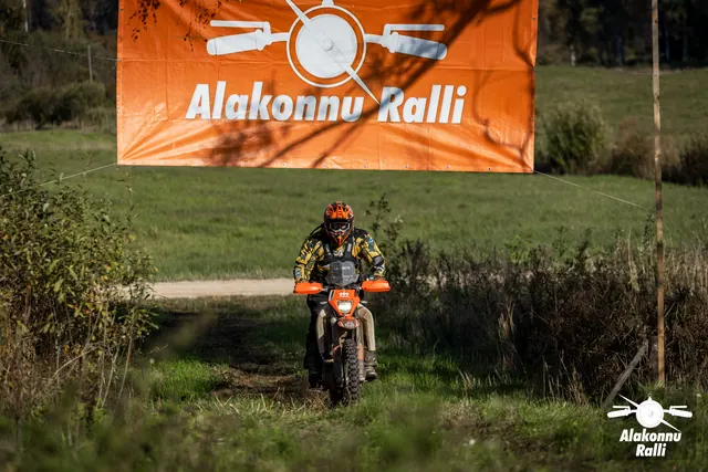 Alakonnu Ralli 2026: sõitja läheneb oranžide käekaitsmetega mootorrattal üle rohelise nõlva.