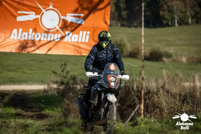 Alakonnu Ralli 2026: kollase ja musta kiivriga osaleja sõidab kõrge esiklaasiga mootorrattal mööda rohurada.