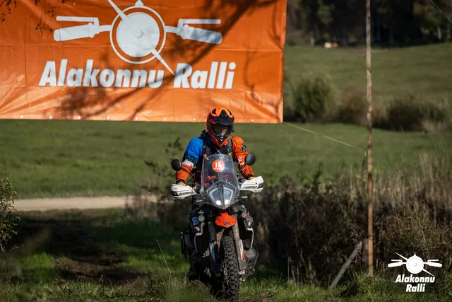Alakonnu Ralli 2026: sinises ja oranžis sõiduvarustuses osaleja sõidab oranžil mootorrattal mööda rohurada.