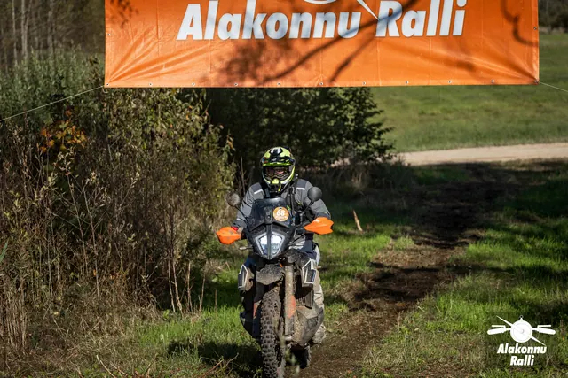 Alakonnu Ralli 2026: kollase ja musta kiivriga sõitja läheneb suure esitulega mootorrattal mööda rohurada.