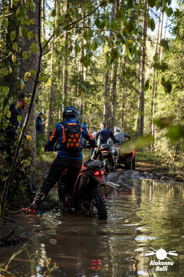Alakonnu Rally 2026: two motorcyclists move through the flooded track between the trees.