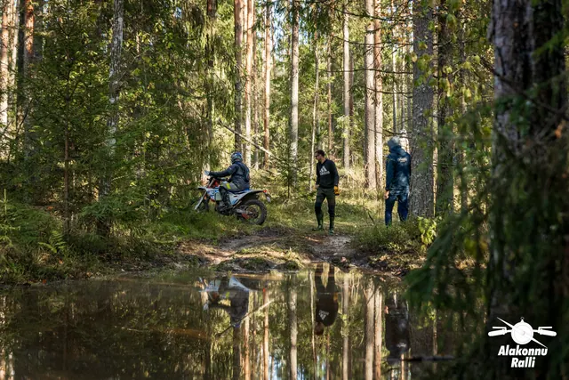 Alakonnu Ralli 2026: inimesed seisavad veetakistuse vastaskaldal, taustal liigub mootorrattur.