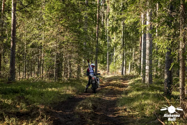 Alakonnu Ralli 2026: mootorrattur sõidab päikeselaigulisel metsarajal veetakistuse poole.