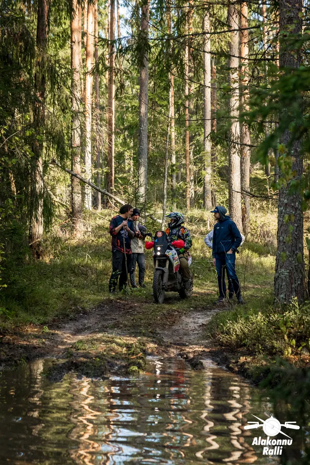 Alakonnu Ralli 2026: inimesed seisavad koos mootorrattaga metsaraja veetakistuse vastaskaldal.