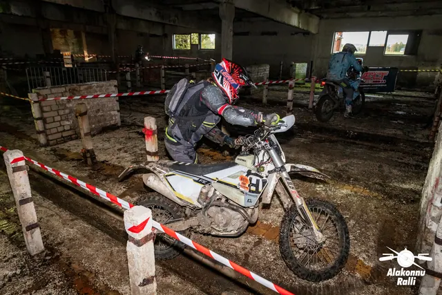 Alakonnu Ralli 2026: punase kiivriga sõitja juhib valget mootorratast hoones läbi kitsa lindiga piiratud koridori.