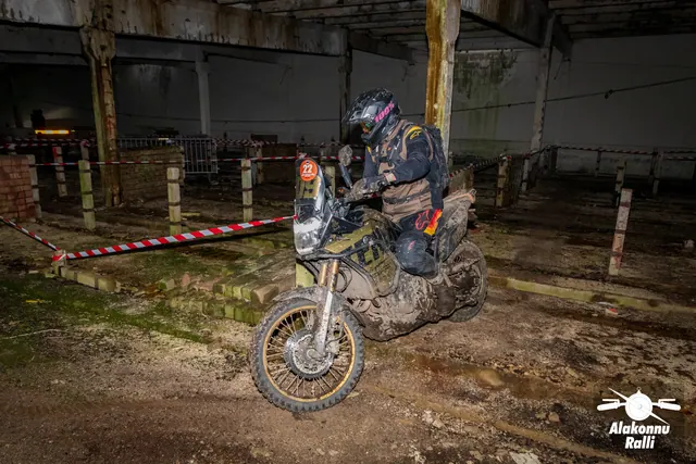 Alakonnu Ralli 2026: mootorrattur väljub hoone hämarast rajakoridorist põleva esitulega.