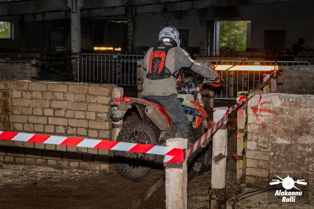 Alakonnu Ralli 2026: hallis sõiduvarustuses osaleja liigub mootorrattal hoones läbi müüride ja rajalintide vahelise kurvi.