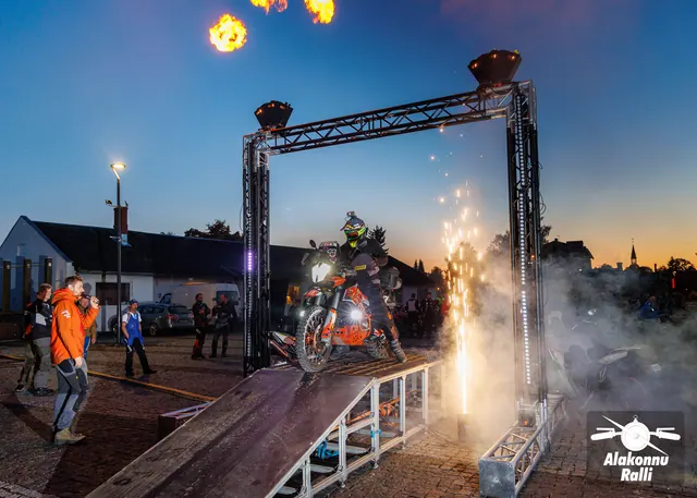 Mootorrattur valgustatud stardivärava all, korraldajad rambi kõrval – Alakonnu Ralli 2026, start ja SS1