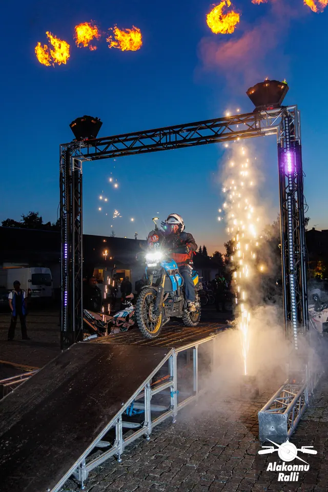 Mootorrattur valgustatud stardivärava all, korraldajad rambi kõrval – Alakonnu Ralli 2026, start ja SS1